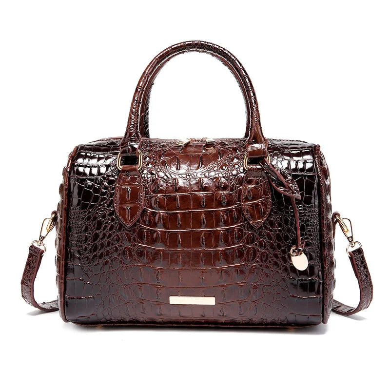 A dark brown crocodile pattern luxury handbag with a leather handle and gold hardware.