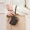 A close-up of a black and gold checkered print accordion card holder wallet being held by a hand.