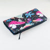 A black canvas wallet featuring a vibrant pattern of mushrooms and floral designs with a pink and purple accent.