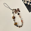 A necklace featuring heart-shaped beads in leopard print and silver accents on a black cord.