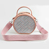 A light pink crossbody bag with a wide adjustable strap featuring an arrow jacquard pattern.