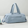 A light blue Oxford gym duffel bag with padded straps resting on a white surface.