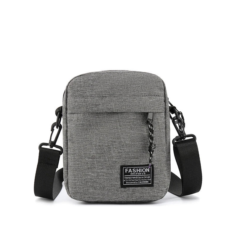 A gray minimalist nylon crossbody bag for men with black strap and buckle.