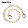 A strand of small, round white pearls used as a strap for a handbag or purse.