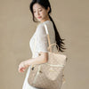A woman wearing a cream-colored dress holds a beige genuine leather women's backpack.