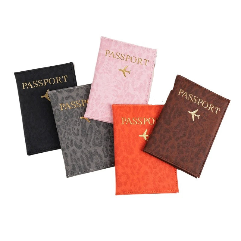 A collection of four passport holders in black, gray, pink, and orange leopard print PU leather.
