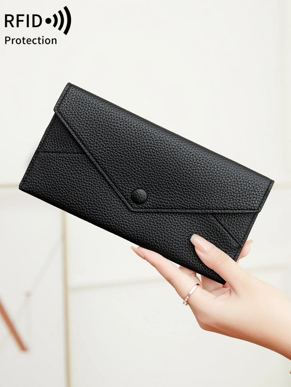A hand holds a black minimalist PU leather coin wallet with a snap closure.