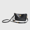 A black classic split leather shoulder tote bag with gold hardware and a long strap.
