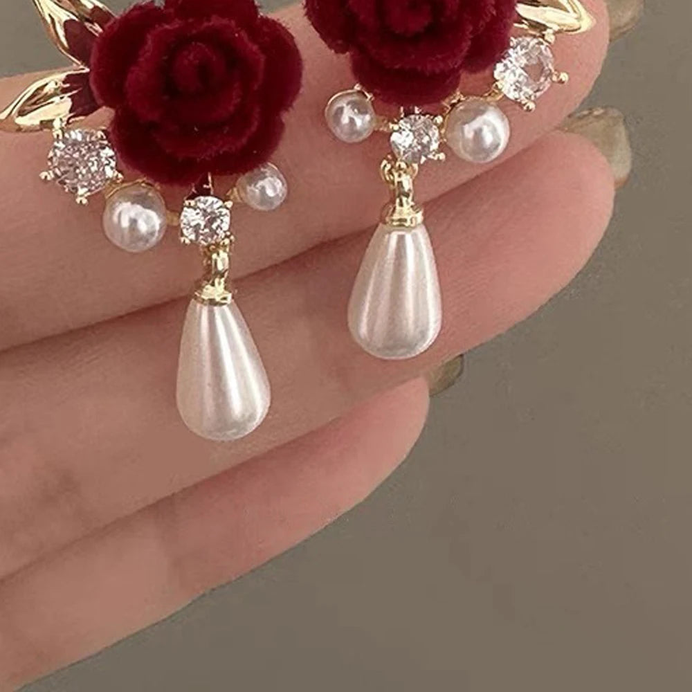 Gold-toned vintage velvet rose earrings featuring clear rhinestones and pearl drops.