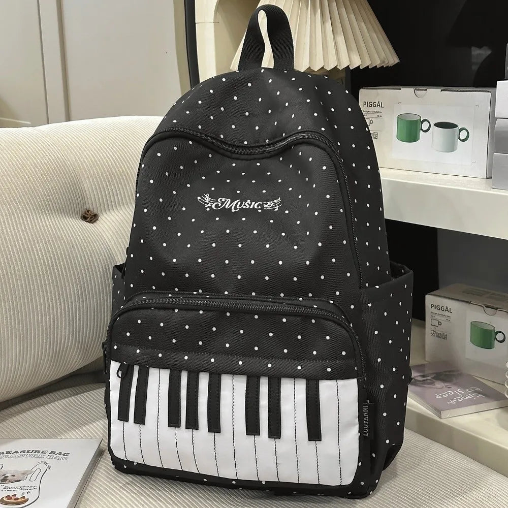 Sac à dos noir à pois blancs avec un motif de note de musique argentée et un clavier de piano blanc.