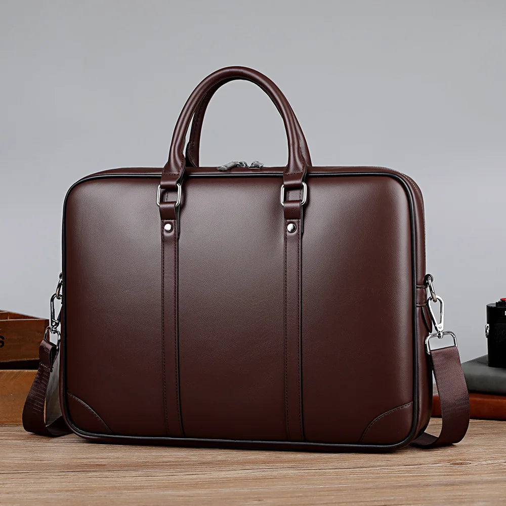 A dark brown luxury PU leather business briefcase with a leather handle and strap is shown on a wooden surface.