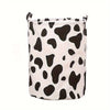 Panier à linge en tissu blanc avec motif vache noire.