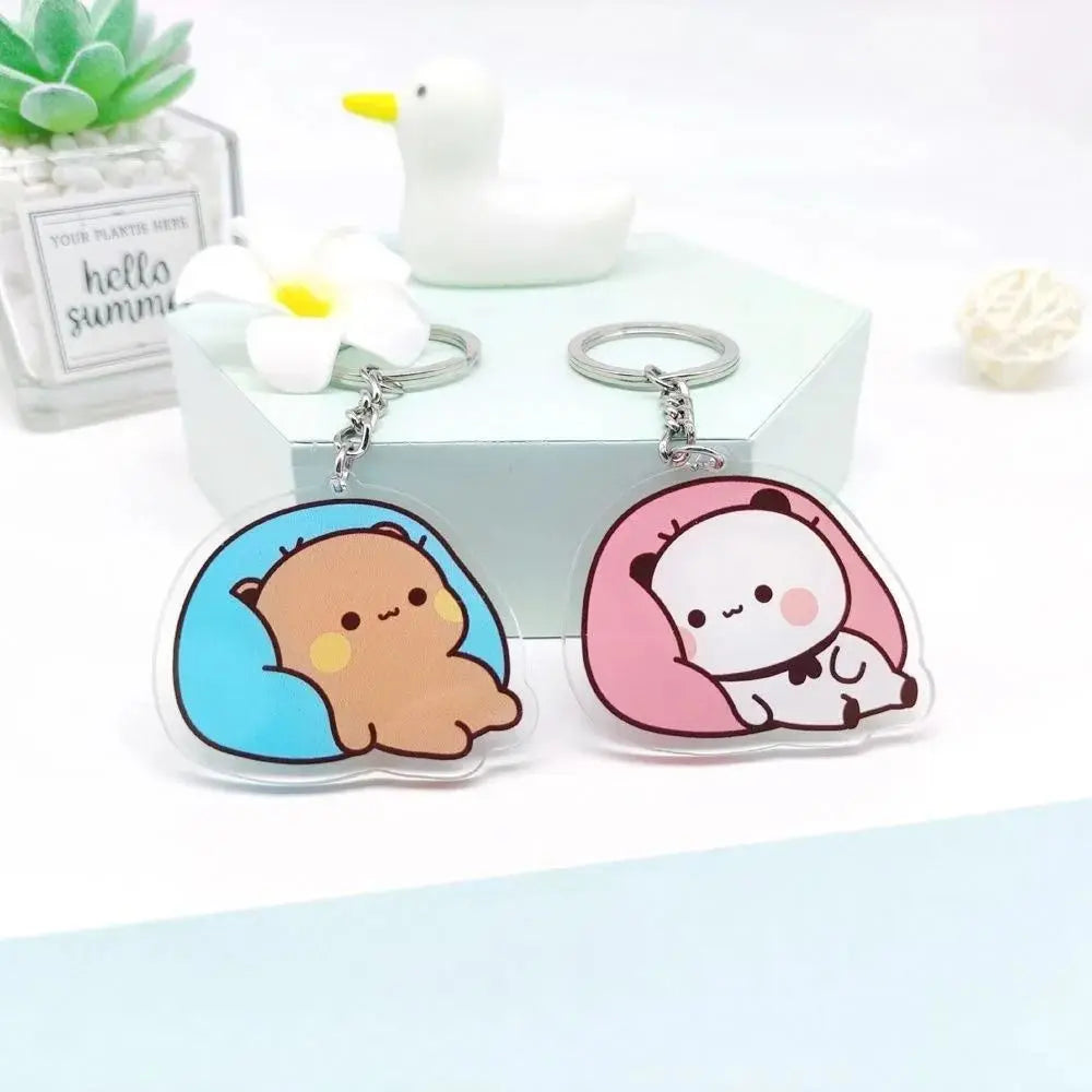 A set of cute cartoon resin keychain charms featuring a yellow duck and a pink panda on silver chains.