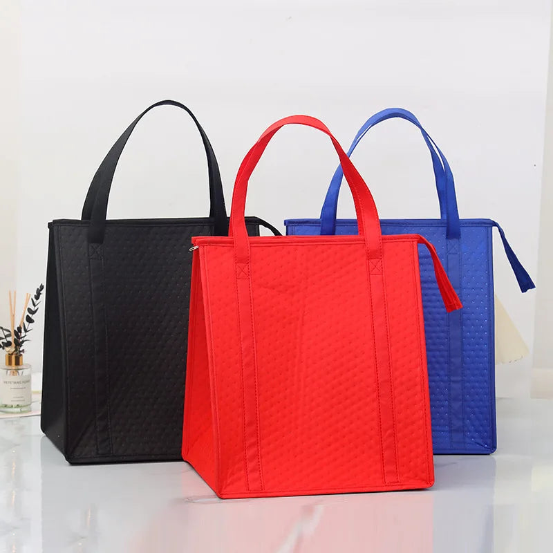 Three insulated tote bags in black, red, and blue standing upright on a white surface.
