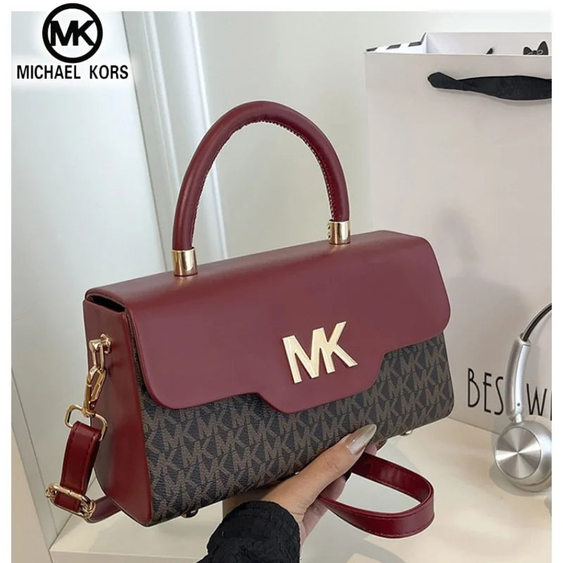 A maroon Michael Kors letter square crossbody bag with gold hardware and a patterned fabric.