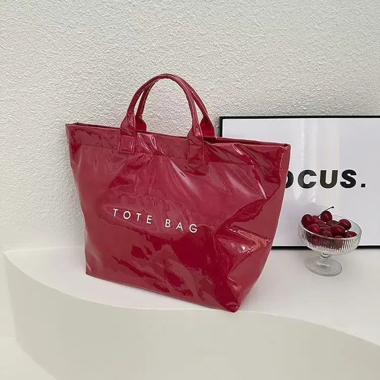 A bright red transparent waterproof PVC tote bag is displayed on a white surface.