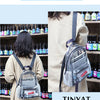 A clear capacity backpack is shown being worn by a person, with various bottles visible in the background.