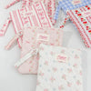 A collection of pink and blue floral plaid cotton tablet pouches with secure closures.
