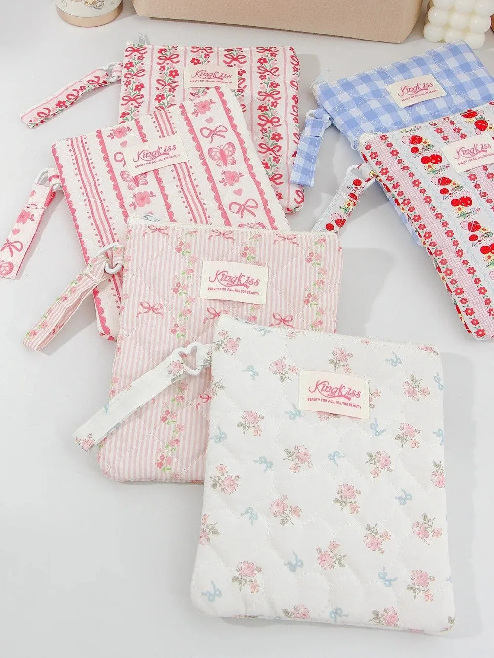 A collection of pink and blue floral plaid cotton tablet pouches with secure closures.