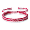 A handmade braided rope bracelet in pink and white yarn, featuring adjustable knots.