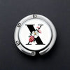 Silver foldable letter hanger hook with a black X design and pink floral accents