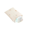 A beige quilted diaper bag tote with a light pink accent, shown from above.