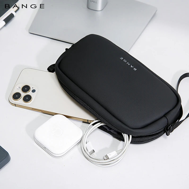 A black travel electronics organizer pouch with a white charging cable and a smartphone resting on a white surface.