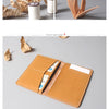 A brown genuine cowhide leather passport and ticket holder with stitched edges and a white insert.