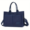 Navy canvas tote handbag with leather accents shown from the front.