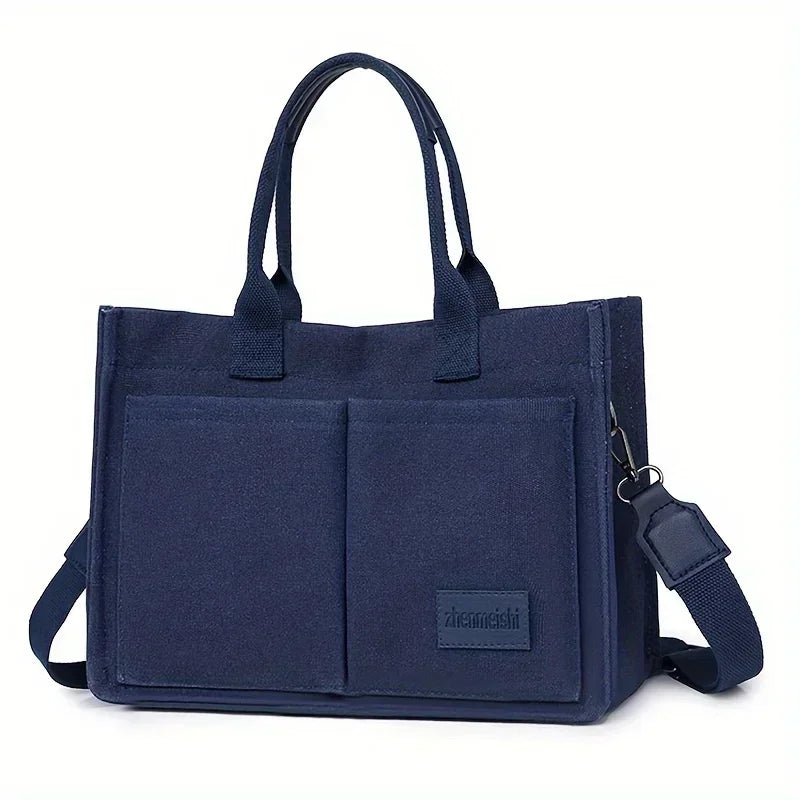 Navy canvas tote handbag with leather accents shown from the front.