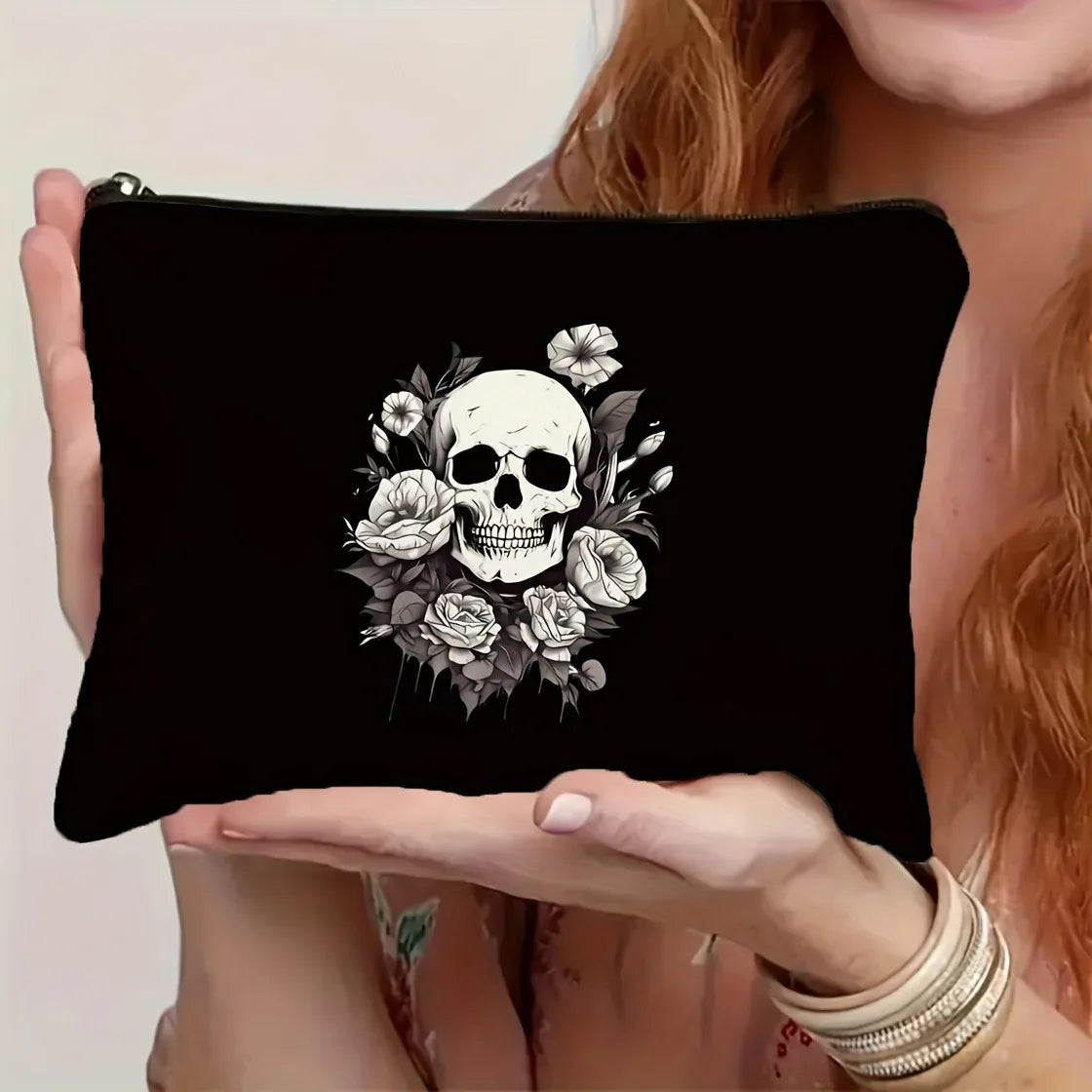 Black zippered pouch featuring a detailed black and white design of roses and a skull