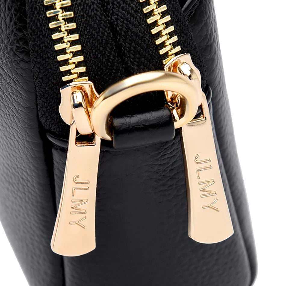 Close-up of a black PU leather trendy shoulder crossbody bag featuring gold-toned zippers and hardware.