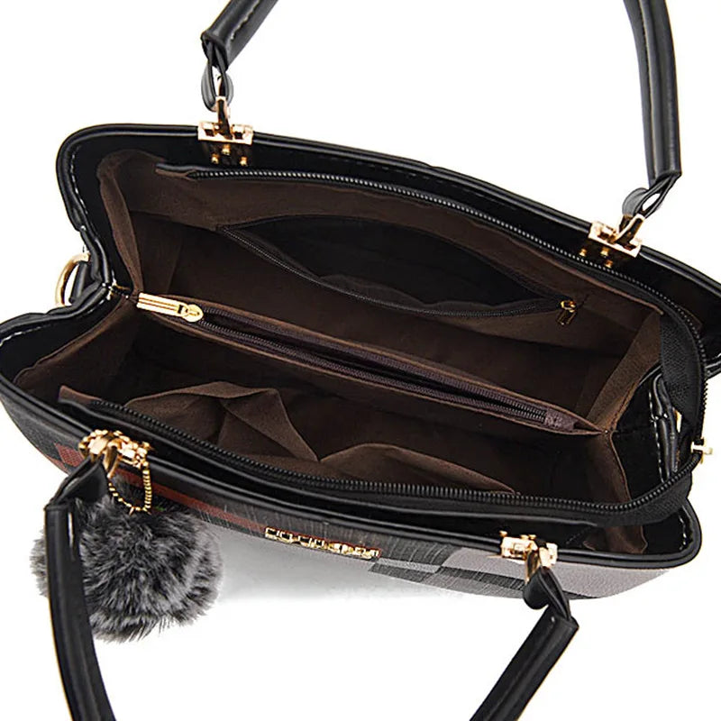 Sac bandoulière en cuir PU noir avec quincaillerie dorée et un charm de fourrure synthétique, ouvert.