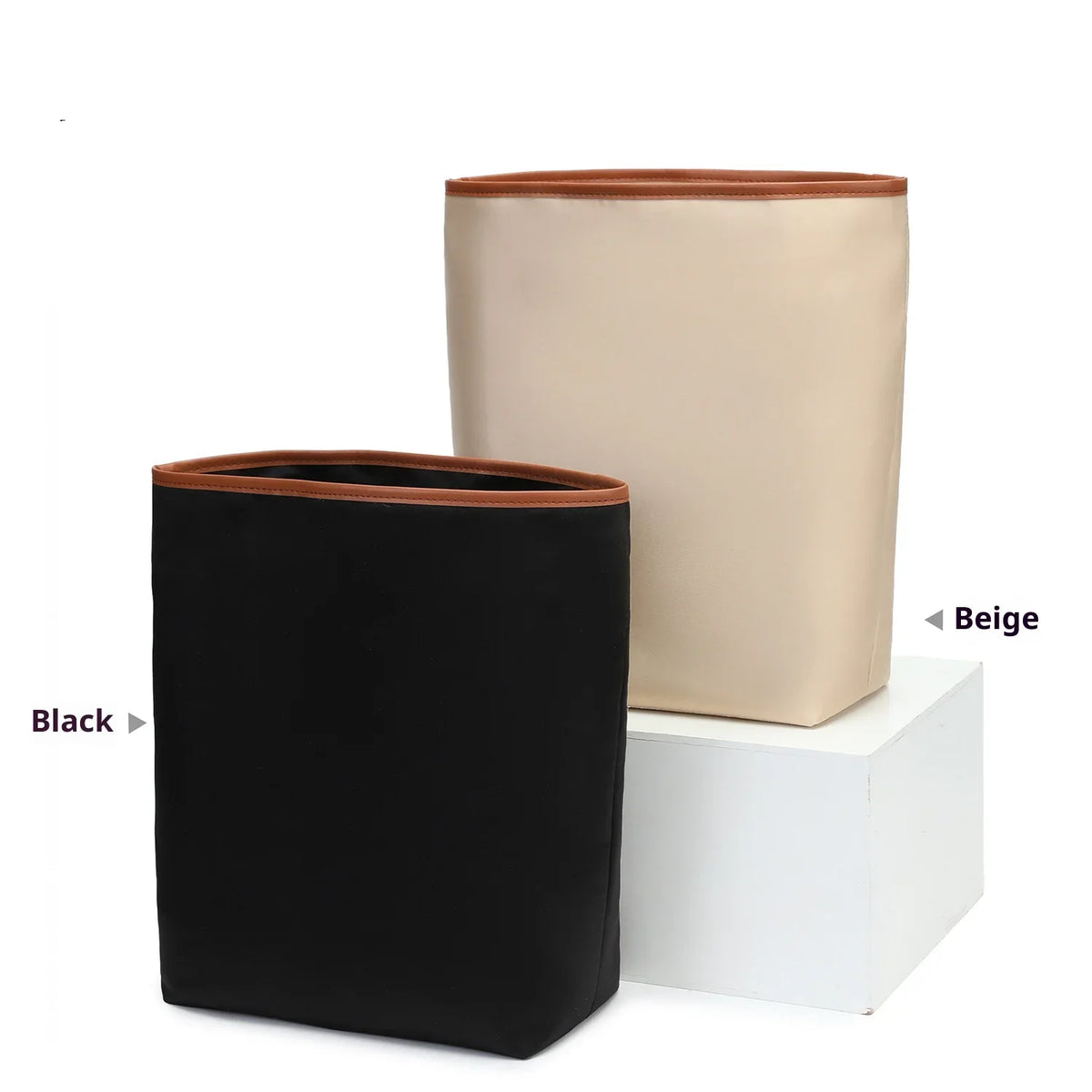 A black satin bag organizer insert next to a beige one, displayed on a white box.