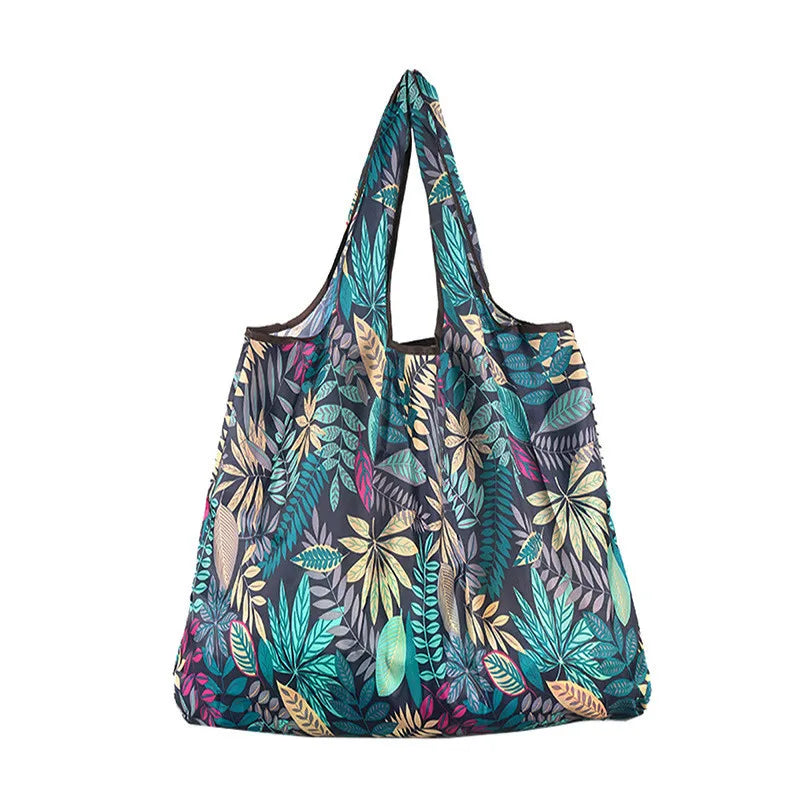 A reusable tote bag made of patterned, teal and green nylon fabric.