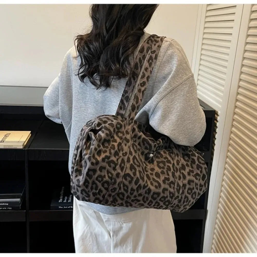 A person is shown from the back carrying a leopard print canvas tote bag with an adjustable shoulder strap.