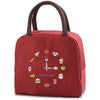 A maroon insulated canvas lunch bag featuring various food icons like a fork, sandwich, and apple.