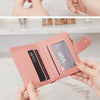 A close-up display of a pink PU leather bifold wallet with an ID window being held by hands.