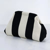 Clutch de crochet a rayas tejido con listones alternados de negro y crema.