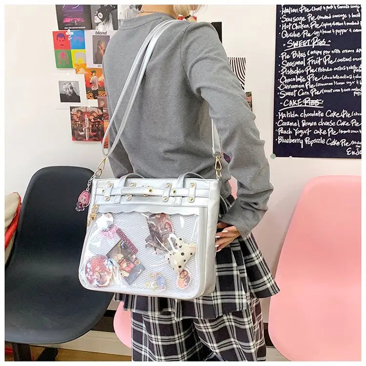 A woman holds a white Y2K punk goth crossbody bag with various charms and a plaid skirt.