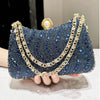 A dark blue rhinestone evening clutch adorned with gold chains and pearl accents.