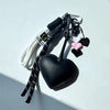 Black and pink heart keychains made of PU leather with braided rope and attached to a white cord.
