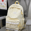 A cream-colored polka dot nylon travel backpack with light yellow straps and a white lace trim.
