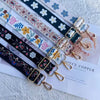 A collection of colorful embroidered nylon bag straps featuring floral and geometric patterns on a white background.