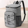 A gray insulated lunch backpack with a waterproof oxford shell and black strap is shown on a light surface.