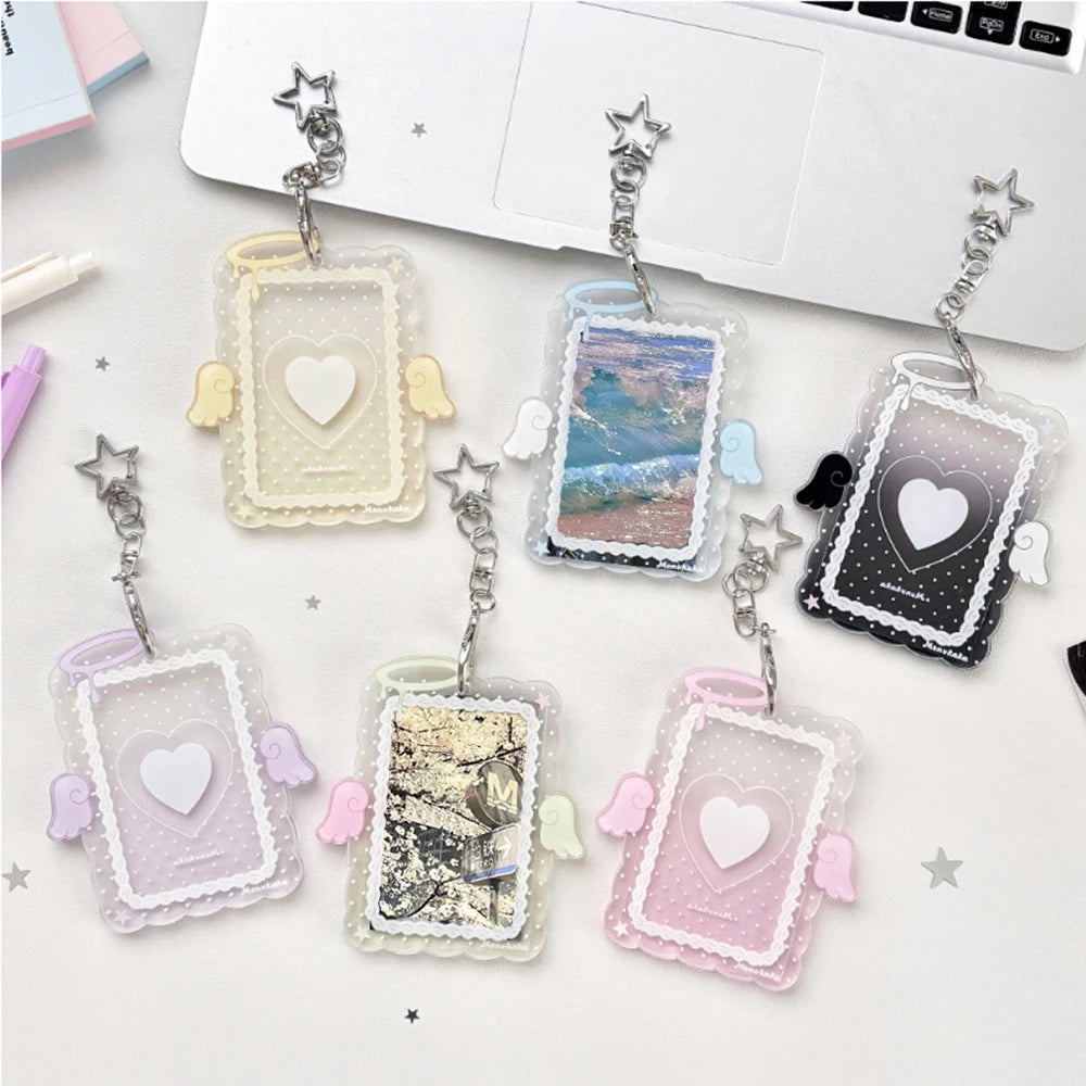 A collection of clear acrylic photo card holders featuring various pastel colors and decorative angel wings.