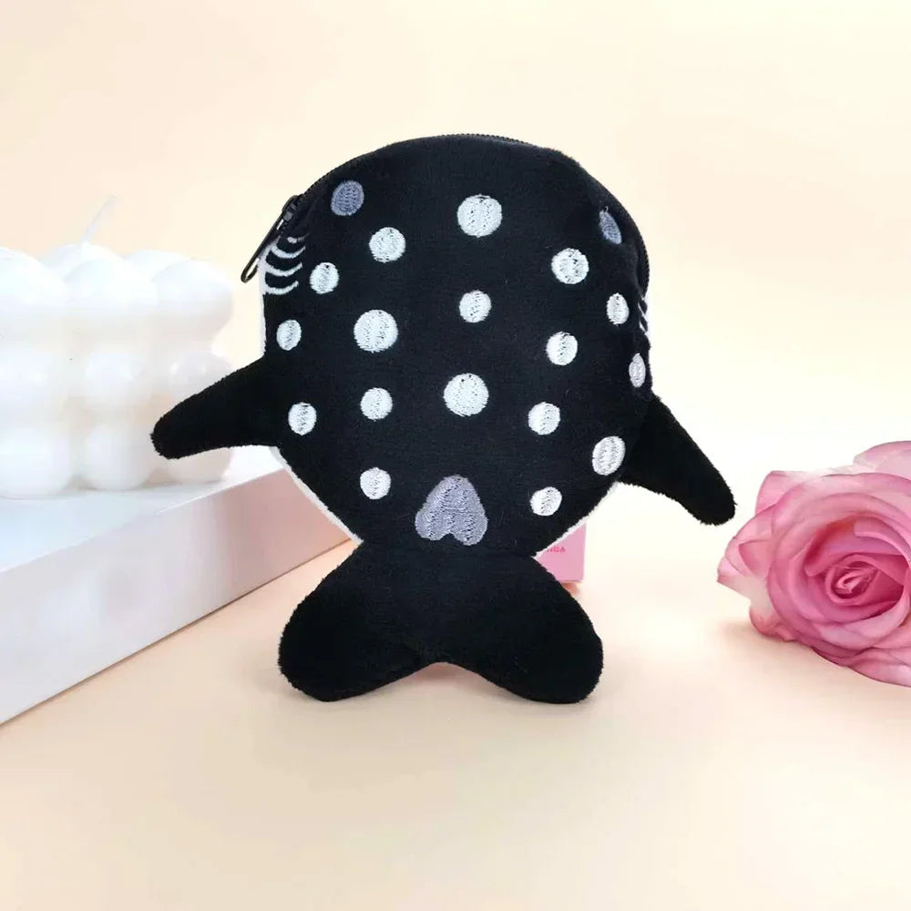 A black shark mini plush coin purse wallet with silver polka dots resting on a light surface.