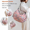 A woman is carrying a pink and green patterned foldable nylon storage bag on her shoulder or over her arm.