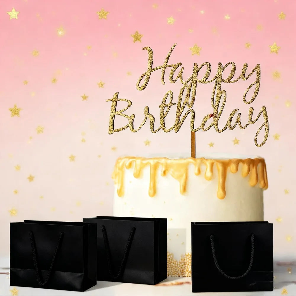 Pastel de cumpleaños blanco con glaseado dorado y una figura que dice Feliz Cumpleaños, junto a bolsas de regalo negras sobre