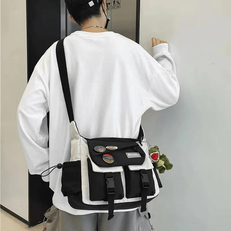 Una persona vista desde atrás, usando una camisa blanca de manga larga y un bolso cruz negro de nylon con detalles claros.
